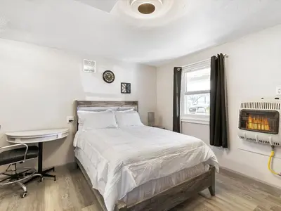 a bedroom with a bed and a desk and a window at Charming Retro Property 6 in Sparks