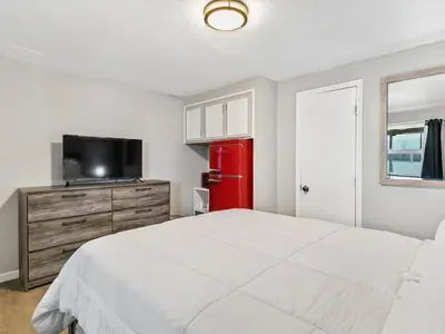 a bedroom with a white bed and a red refrigerator at Charming Retro Property #3! in Sparks