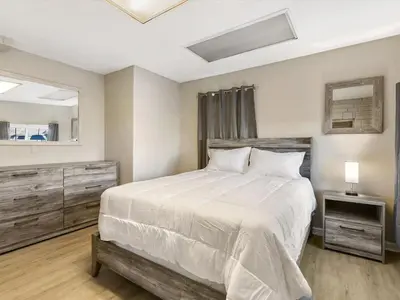 a bedroom with a large white bed and a mirror at Charming Retro Property 22 in Sparks