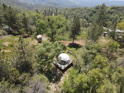 an aerial view of a tent in a field with trees at Enchanted Forest Dome ,10-15 minutes to Kings Canyons-New pellet stove for cozy warm nights in Dunlap