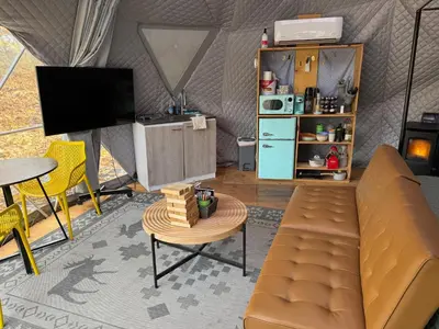 a living room with a couch and a table at Enchanted Forest Dome ,10-15 minutes to Kings Canyons-New pellet stove for cozy warm nights in Dunlap