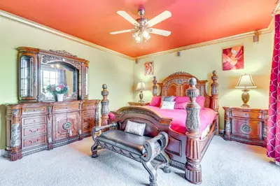 a bedroom with a large wooden bed and a mirror at Outdoor Oasis and Hot Tub! Spacious Clovis Home in Clovis