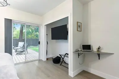 a bedroom with a bed and a desk with a laptop at East Sac Getaway, Walking Distance to Hospitals in Sacramento