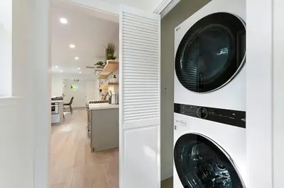 a laundry room with a washer and dryer and a kitchen at East Sac Getaway, Walking Distance to Hospitals in Sacramento