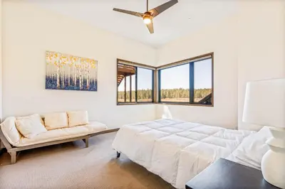 a white bedroom with a bed and a couch at Meadowlark in Tahoe Donner - Modern 4BR w great views, hot tub & HOA amenities in Truckee