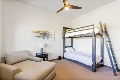 a bedroom with a bunk bed and a couch at Meadowlark in Tahoe Donner - Modern 4BR w great views, hot tub & HOA amenities in Truckee