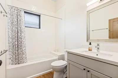 a white bathroom with a toilet and a sink at Meadowlark in Tahoe Donner - Modern 4BR w great views, hot tub & HOA amenities in Truckee