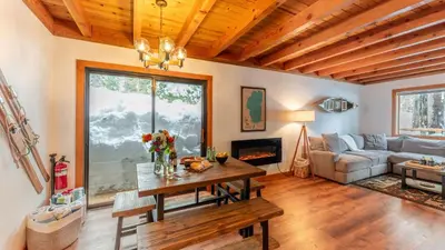 a living room with a table and a couch at Minutes to Skiing Lake Hot Tub Fire Pit Deck Indigo Owl by AvantStay in Homewood