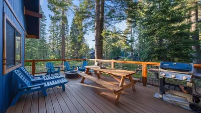 a wooden deck with a picnic table and a grill at Minutes to Skiing Lake Hot Tub Fire Pit Deck Indigo Owl by AvantStay in Homewood