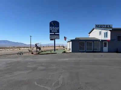 a sign for a motel with a horse statue in front of it at Star Inn in Tonopah