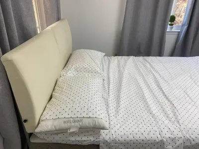 a bed with a white comforter and a pillow at Scenic view villa near Yosemite in Groveland