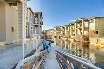 a canal with houses and a blue boat in it at Theater Room, Fireplace Home 5 Mi to Dtwn Reno! in Sparks