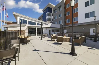 a courtyard with chairs and tables in front of a building at Residence Inn by Marriott Lodi Stockton in Lodi