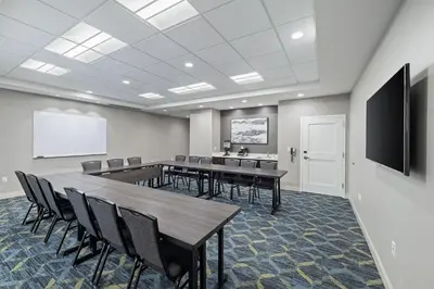 a conference room with tables and chairs and a screen at Residence Inn by Marriott Lodi Stockton in Lodi