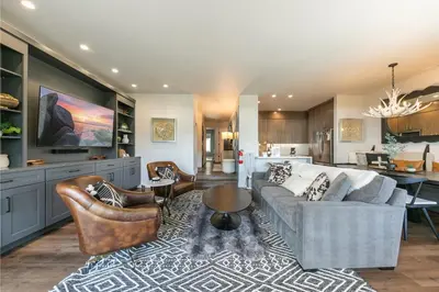 a living room with a couch and chairs and a kitchen at Stylish 2BD Condo - Walk to Palisades! in Olympic Valley