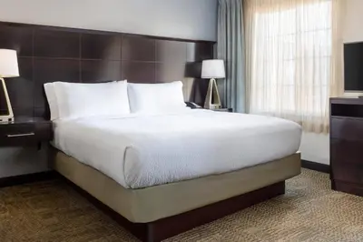 a large bed in a hotel room with two lamps at Staybridge Suites Sacramento-Folsom by IHG in Folsom