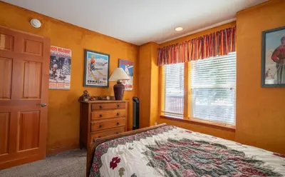 a bedroom with a bed and a dresser and a window at Hideaway Down Canyon #101 in June Lake