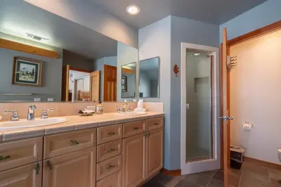a bathroom with two sinks and a large mirror at Hideaway Down Canyon #101 in June Lake