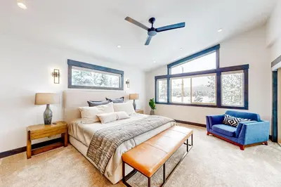 a bedroom with a bed and a blue chair at Mountain Majesty in Truckee