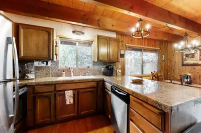 a kitchen with wooden cabinets and a sink and a refrigerator at Cardinal's Nest in Groveland