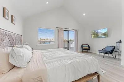 a white bedroom with a large bed and a window at * Large Updated Waterfront Delta Manor Boat Dock * in Discovery Bay
