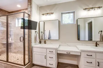 a bathroom with two sinks and a shower at Game Room and Pool Access Spacious Cabin in Arnold in Arnold