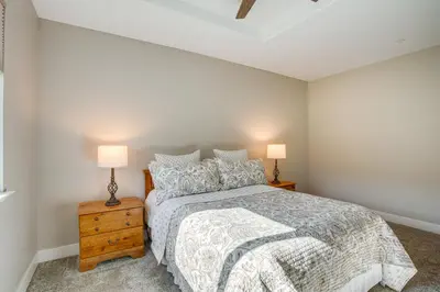 a bedroom with a bed and two lamps at Game Room and Pool Access Spacious Cabin in Arnold in Arnold