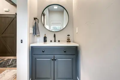 a bathroom with a blue cabinet and a mirror at Game Room and Pool Access Spacious Cabin in Arnold in Arnold