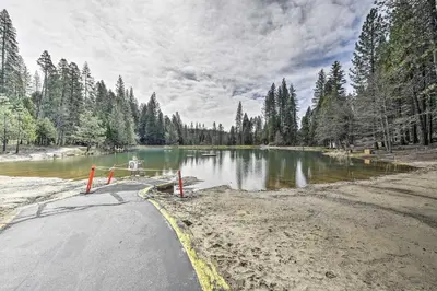 a road next to a body of water with trees at Game Room and Pool Access Spacious Cabin in Arnold in Arnold