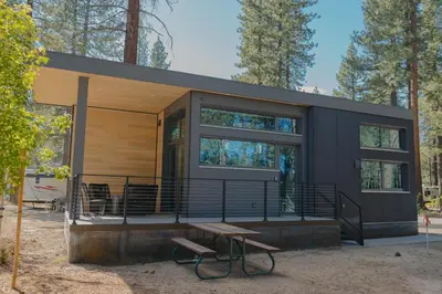 a small black house with a picnic table in front of it at Village Camp Truckee in Truckee