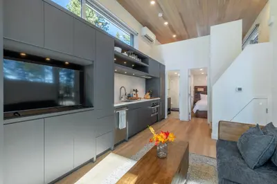 a kitchen and living room with a large flat screen tv at Village Camp Truckee in Truckee