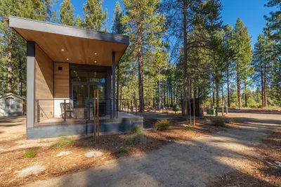 a modern house in the woods with trees at Village Camp Truckee in Truckee
