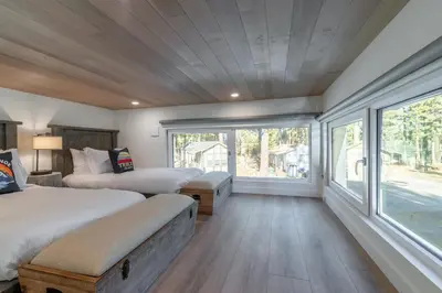 a bedroom with two beds and a large window at Village Camp Truckee in Truckee