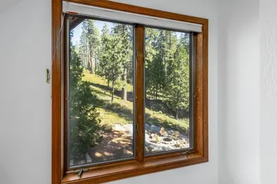 a window with a view of a forest at WHouse*HotTub*Sleeps20*BLS*FirePit*AC&Heat*DogsOk in Arnold
