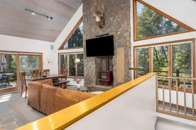 a living room with a couch and a stone fireplace at WHouse*HotTub*Sleeps20*BLS*FirePit*AC&Heat*DogsOk in Arnold