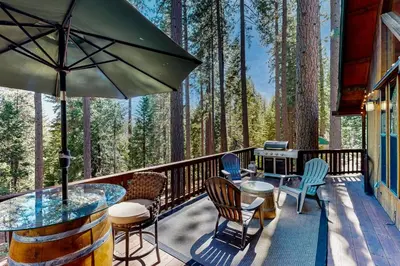 a deck with chairs and a table and an umbrella at Hot Tub Hideaway in Dorrington
