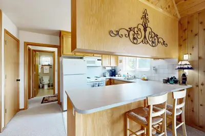 a kitchen with a white refrigerator and wooden cabinets at Cozy Chalet in Arnold