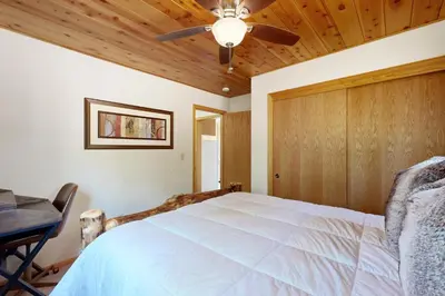 a bedroom with a bed and a ceiling fan at Cozy Chalet in Arnold