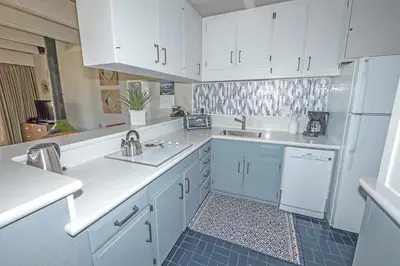 a kitchen with white cabinets and a sink at Ala Wai BoulevardApartment 23 in Lake Valley
