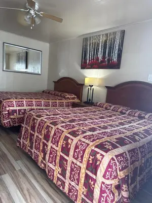 a hotel room with two beds and a ceiling fan at Jerry's Motel in Oakdale