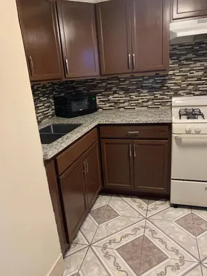 a kitchen with wooden cabinets and a stove top oven at Jerry's Motel in Oakdale