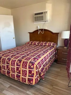 a bedroom with a bed and a air conditioner at Jerry's Motel in Oakdale