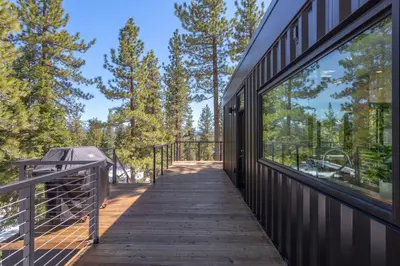 a walkway leading to a building with large windows at Modern Eco Retreat with Hot Tub and Views in Truckee