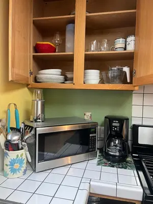 a kitchen with a microwave oven and cabinets with dishes at Suite Sunshine A in Yosemite West