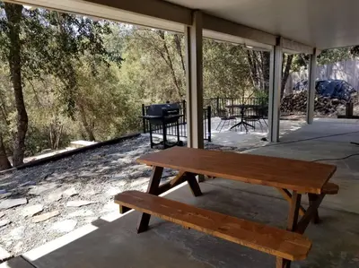 a wooden bench sitting on top of a patio at Riverside Manna in Mariposa