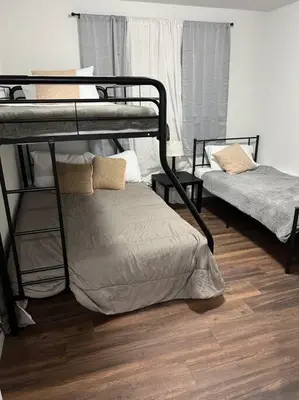 two bunk beds in a room with a wooden floor at Sequoia Villa in Visalia