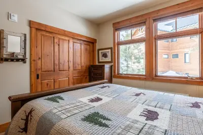 a bedroom with a bed and a window at Cabins 24 in Mammoth Lakes