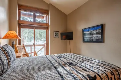 a bedroom with a bed and a window at Cabins 24 in Mammoth Lakes