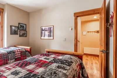 a bedroom with two beds and a door at Cabins 24 in Mammoth Lakes