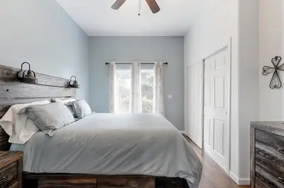 a bedroom with a white bed and a window at Hot Tub and Expansive Views Copperopolis Mtn Home in Copper Cove Subdivision